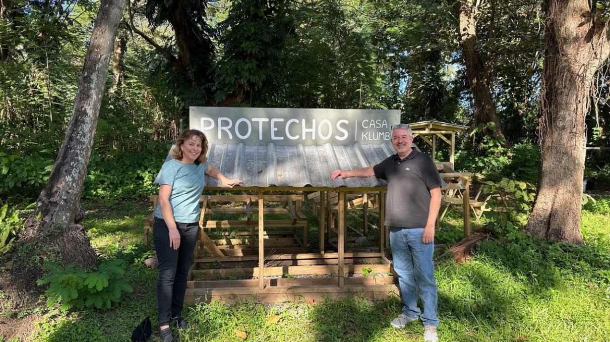 Emily stands next to fellow founder in front of ProTechos warehouse sign.